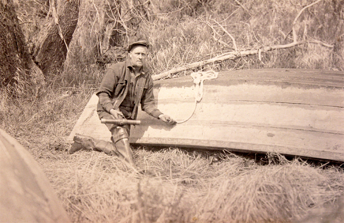 For sale: 1920's RPPC of an Alaska man calking a
              wooden boat.